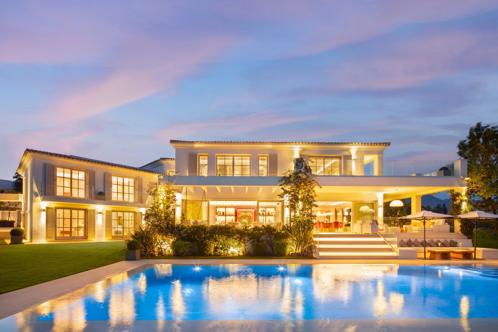 Evening view of the villa and illuminated swimming pool