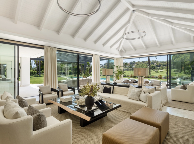 Bright living room with vaulted ceiling and full-height windows