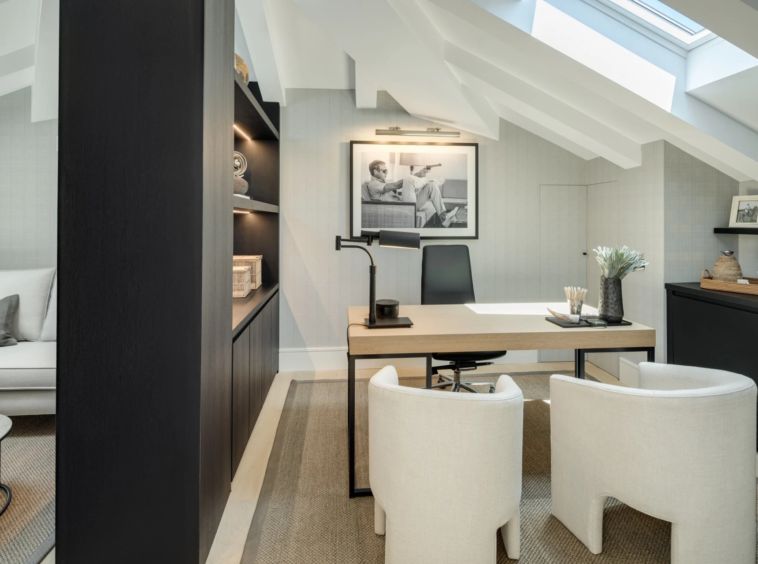 Home office beneath a sloping ceiling with built-in desk