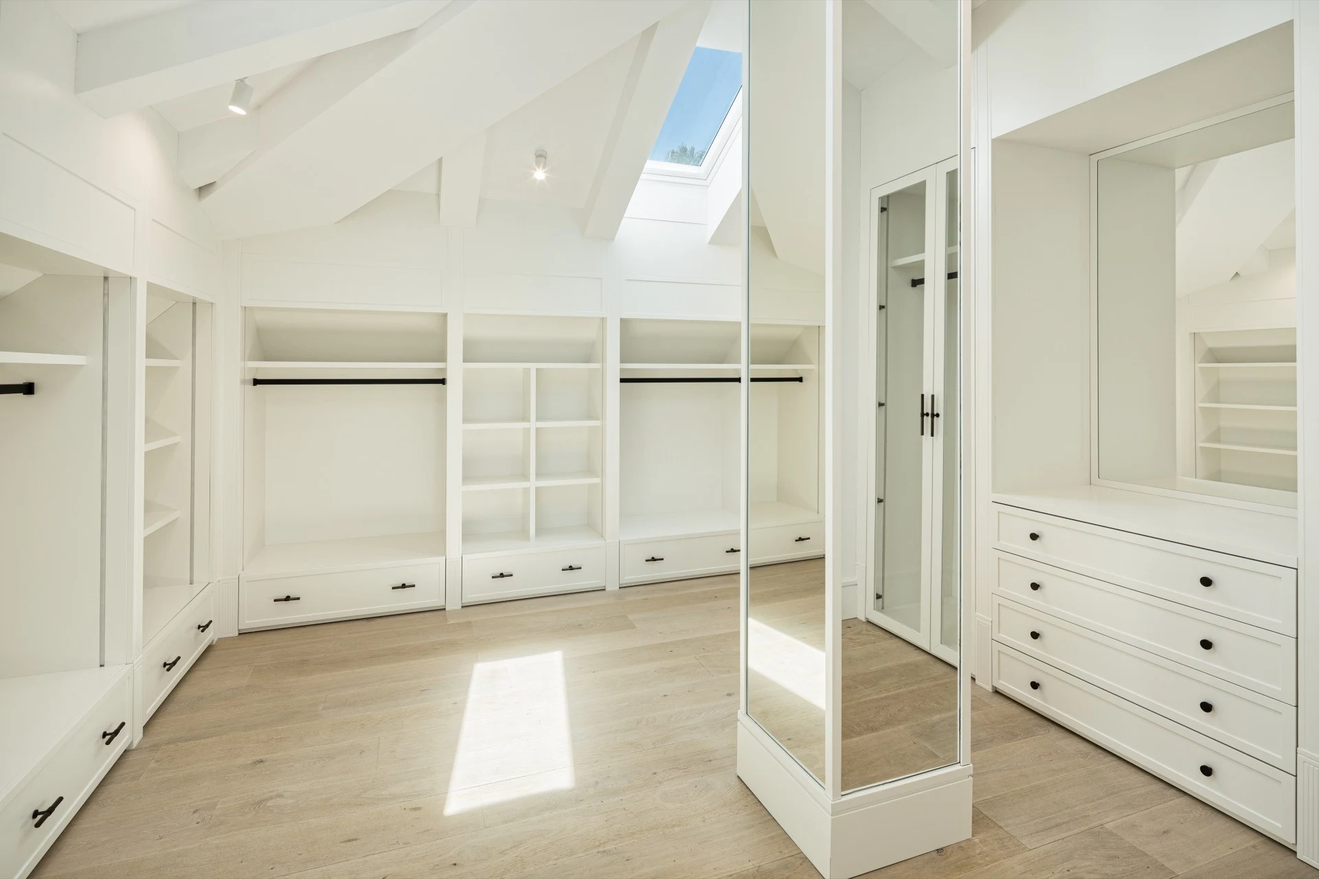 Walk-in dressing room with fitted wardrobes and central storage