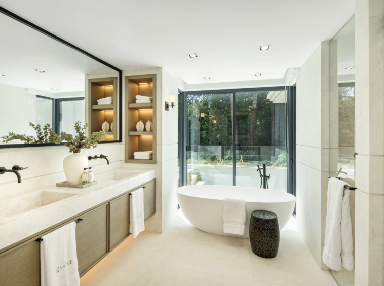 Bathroom with freestanding bath and garden-facing glazing