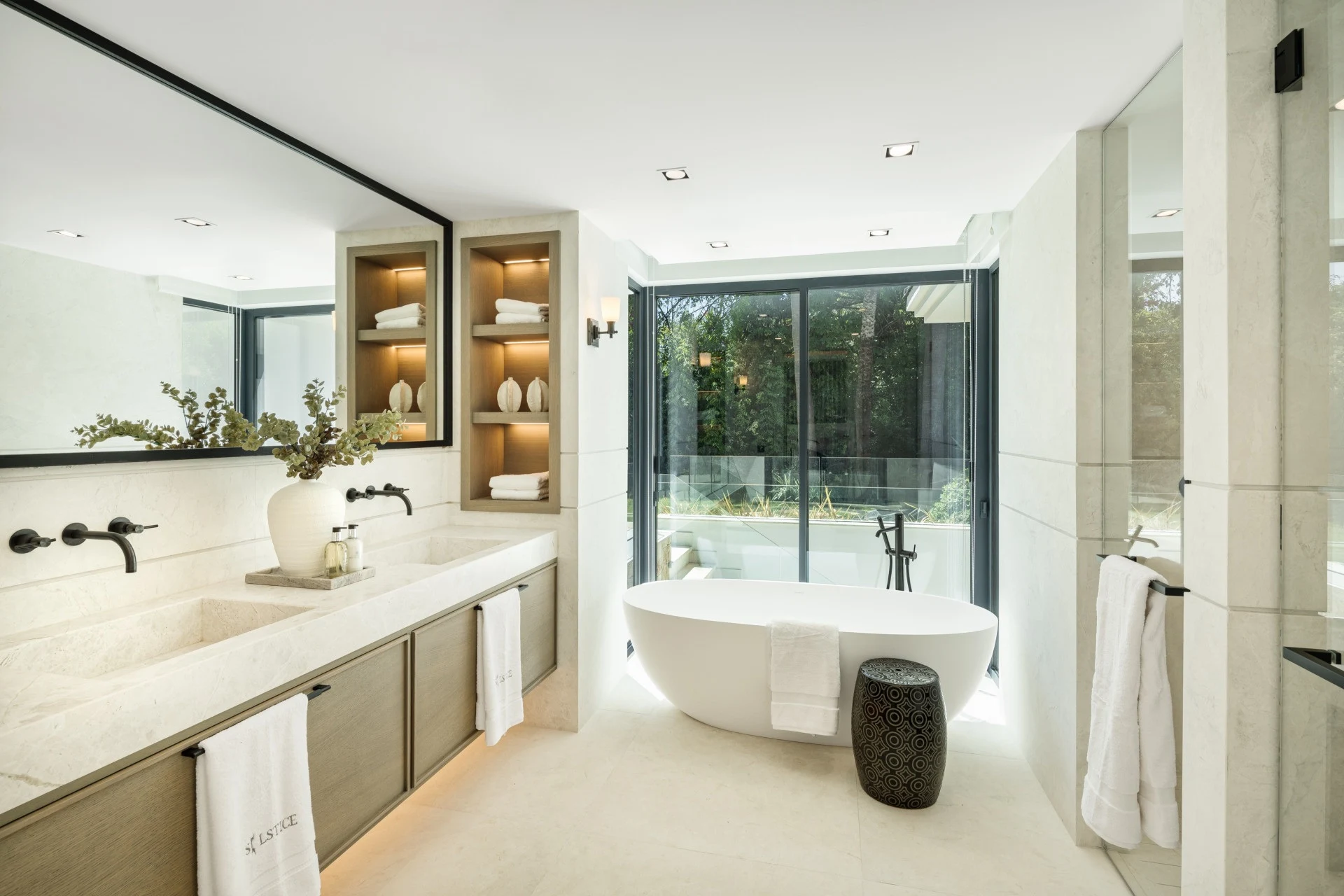 Bathroom with freestanding bath and garden-facing glazing