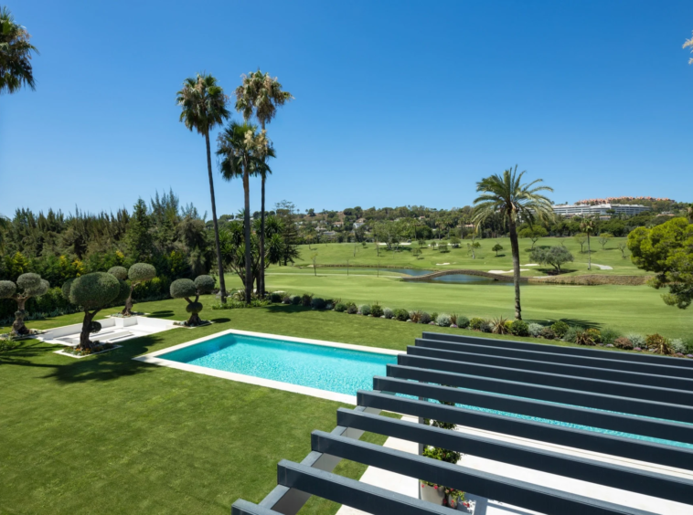 Upper terrace view over the private pool and neighbouring golf course