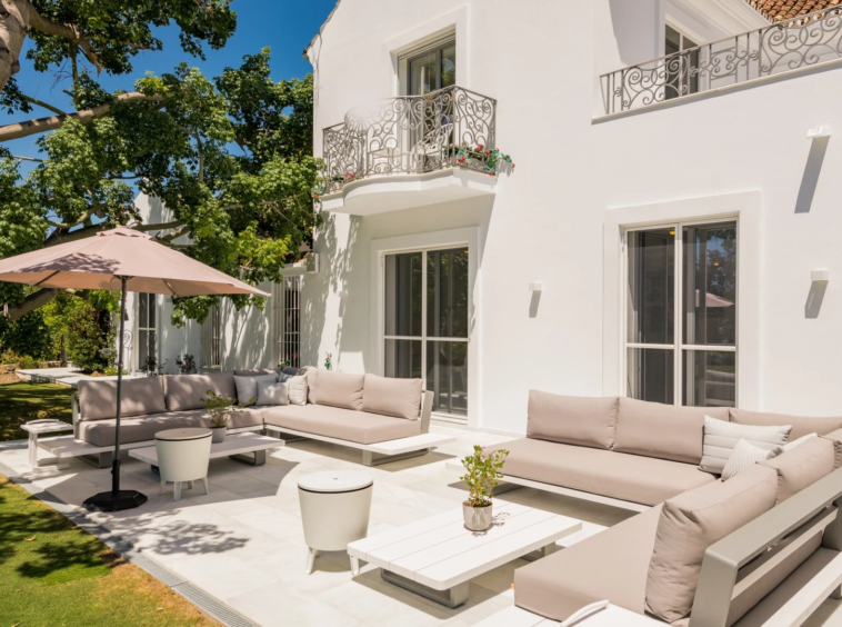 Poolside lounge terrace beside the white villa facade