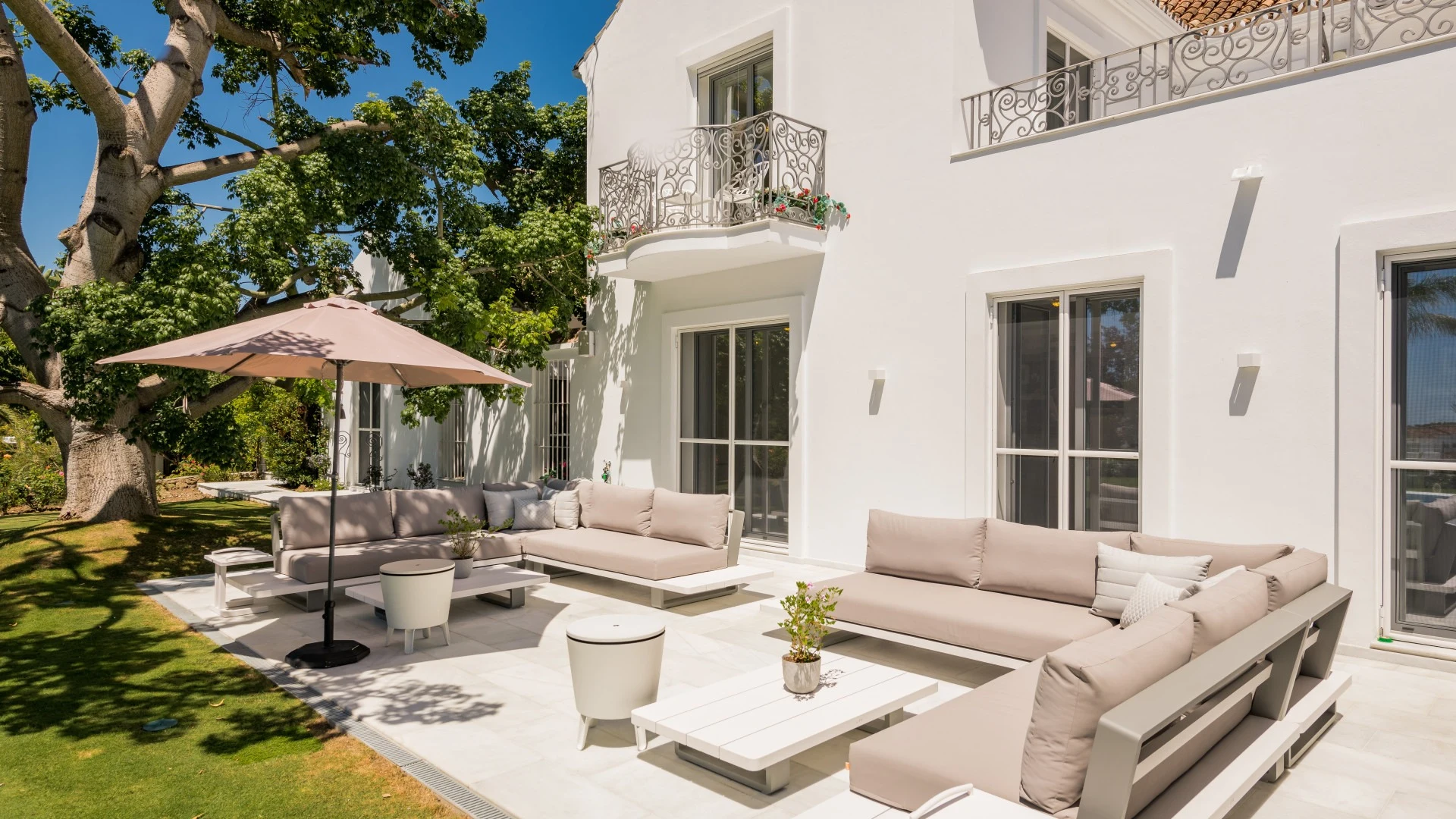 Poolside lounge terrace beside the white villa facade
