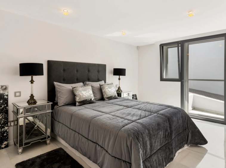 Guest bedroom with upholstered bed and large window