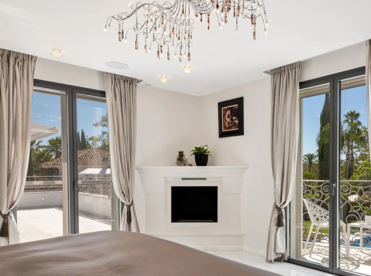 Principal bedroom with fireplace and terrace doors