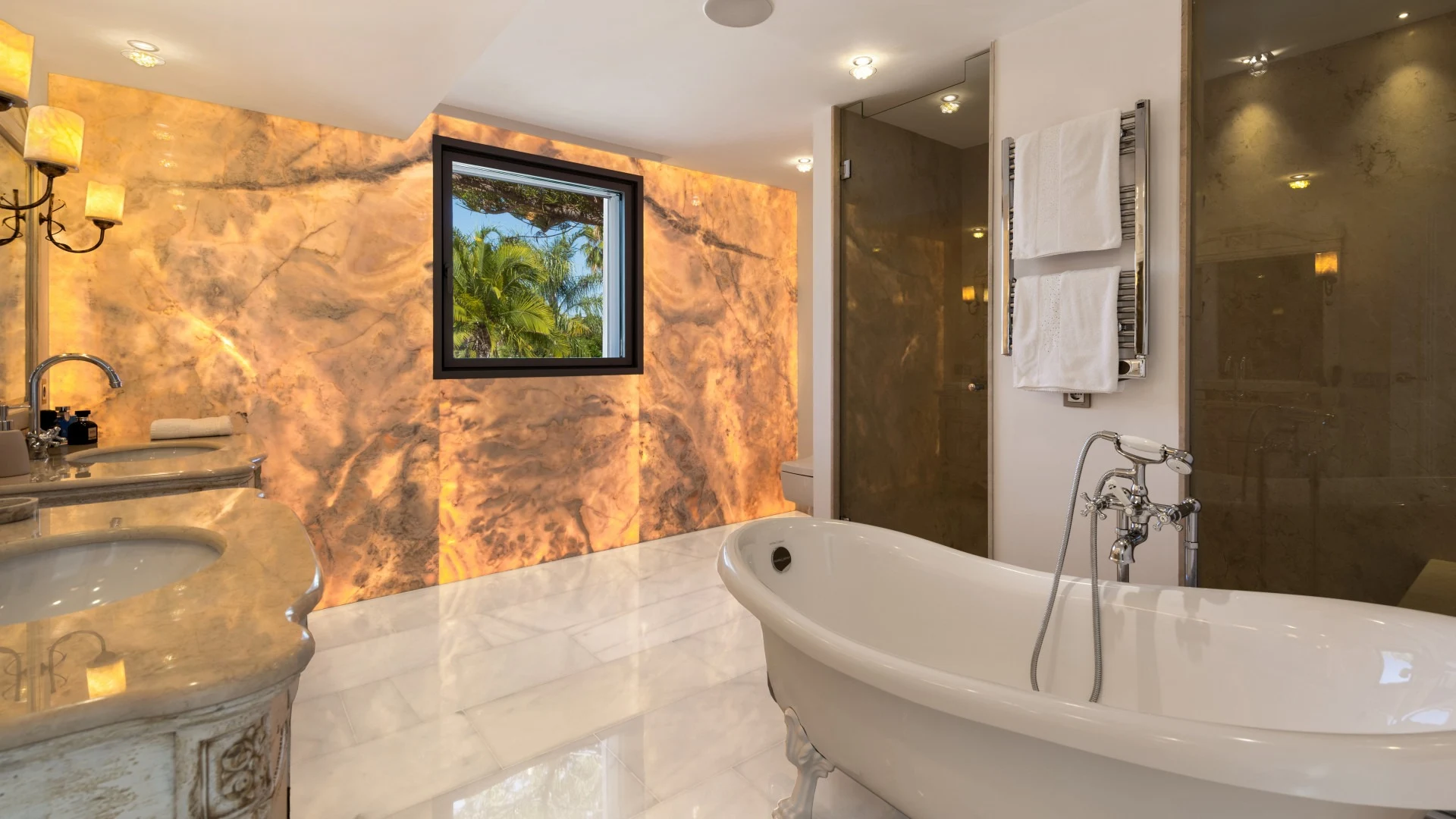 Bathroom with freestanding bathtub and illuminated stone wall