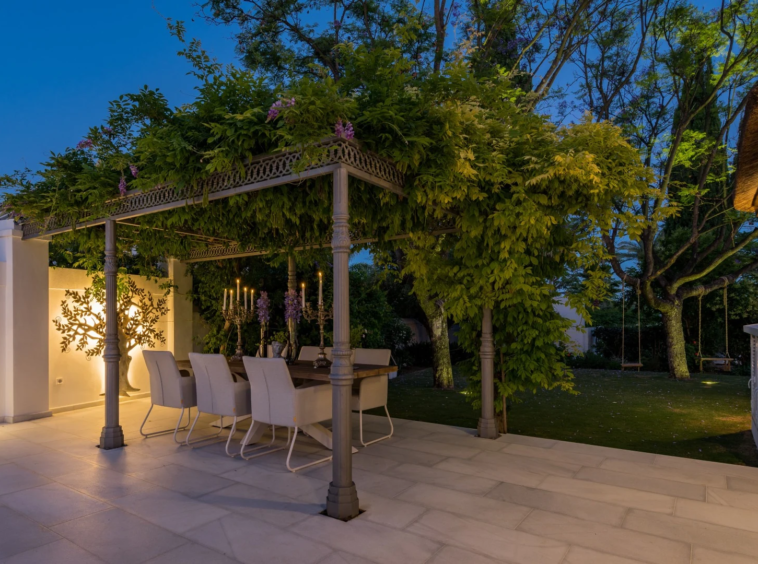 Outdoor dining area beneath a garden pergola