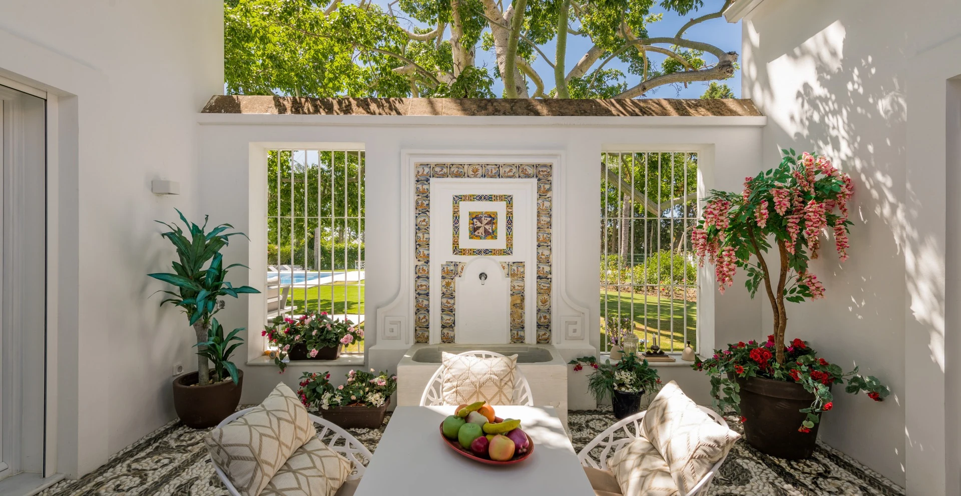 Tiled courtyard with a decorative fountain and climbing plants