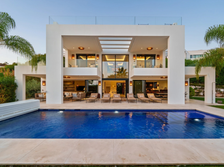 Front elevation of the six-bedroom villa and swimming pool at dusk