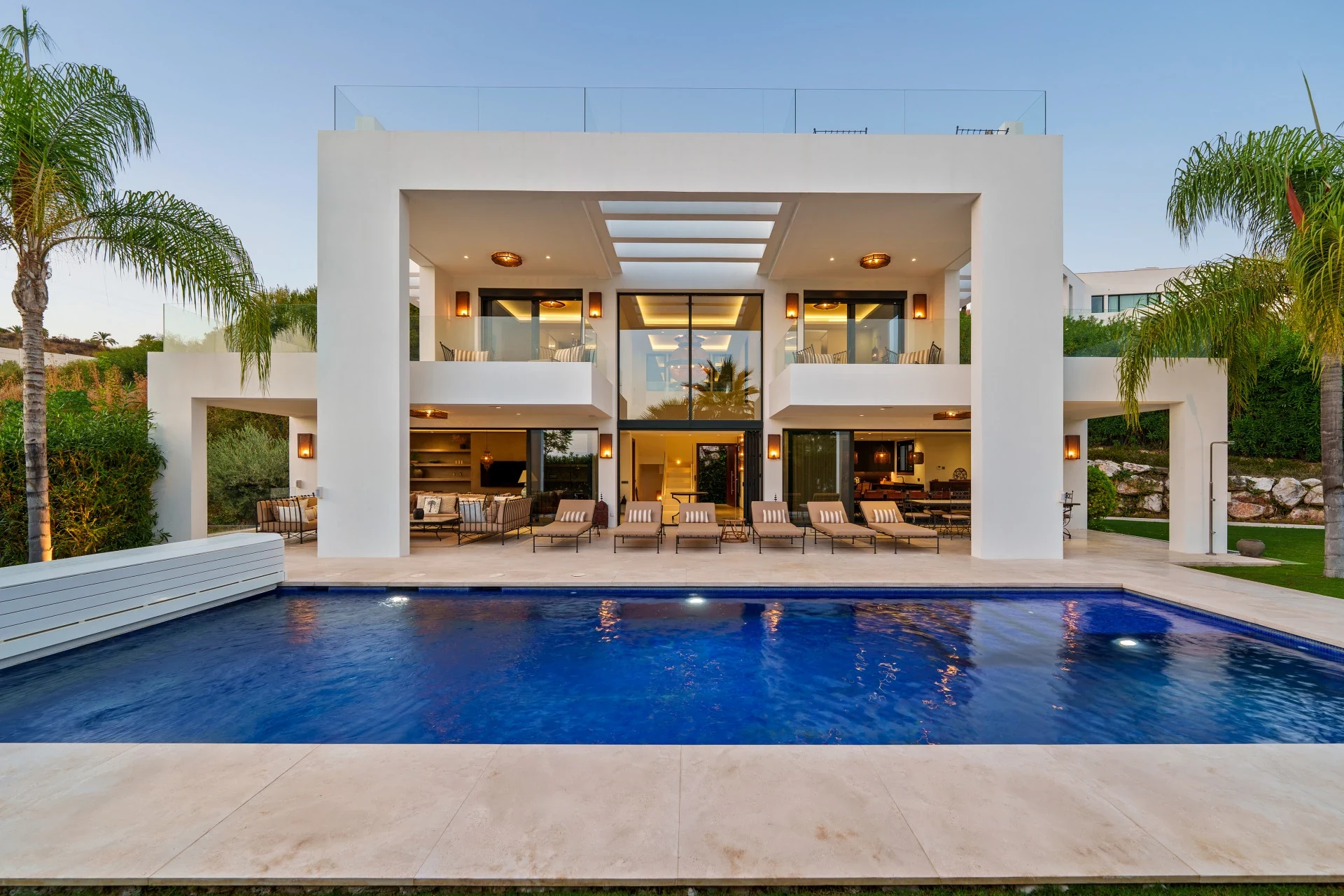 Front elevation of the six-bedroom villa and swimming pool at dusk