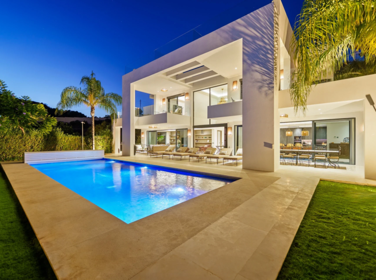 Illuminated villa and private swimming pool in the evening