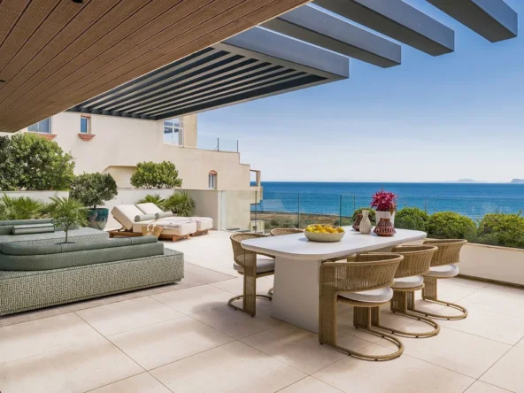 Beachfront apartment terrace with shaded dining and Mediterranean views