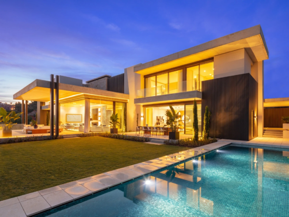 Contemporary La Quinta villa illuminated beside the private pool at dusk
