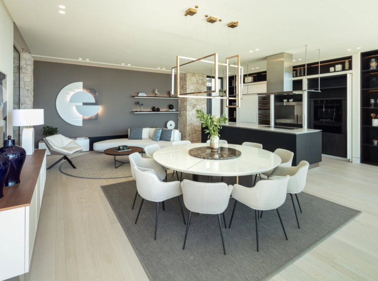 Round dining table beside the open kitchen and fitted display shelves