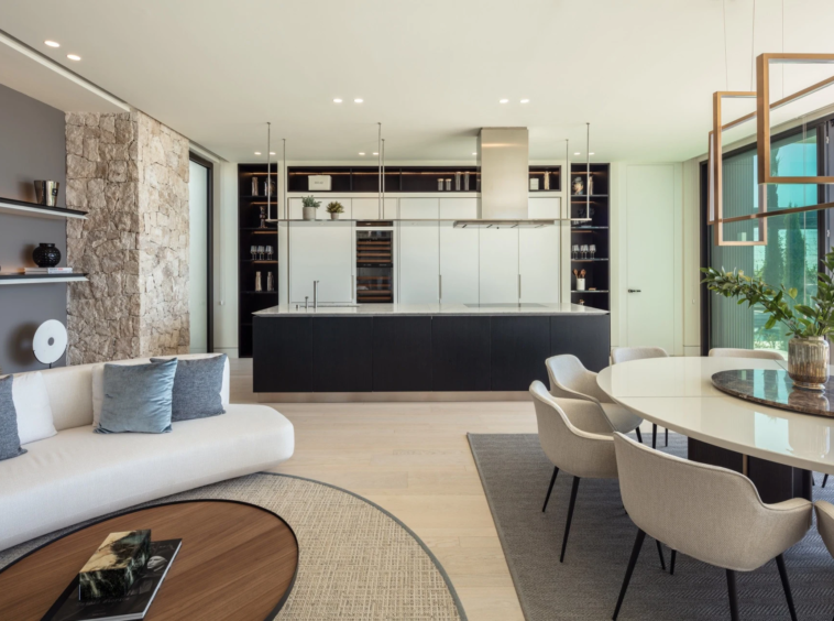 Dark fitted kitchen with integrated appliances and adjoining seating