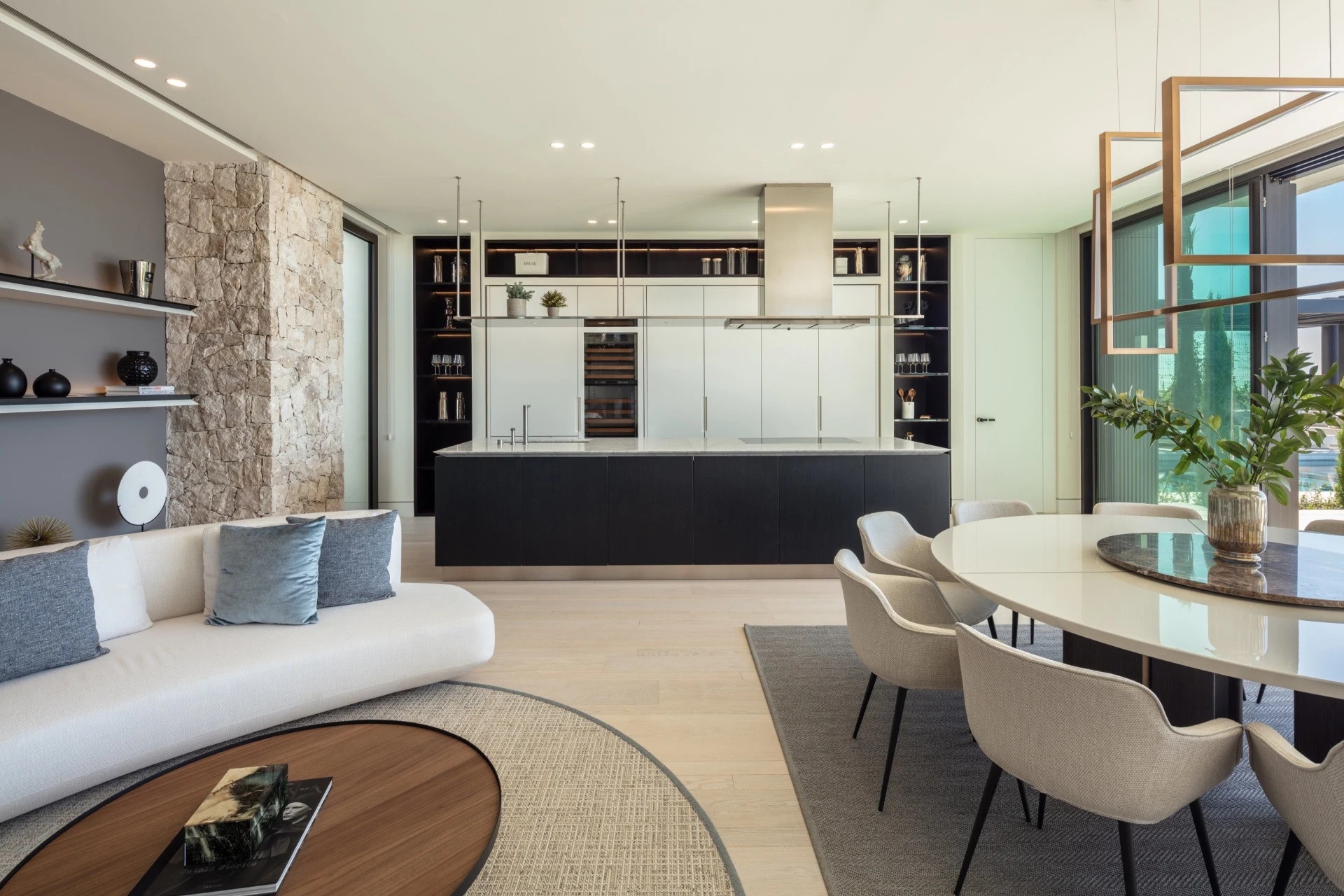 Dark fitted kitchen with integrated appliances and adjoining seating