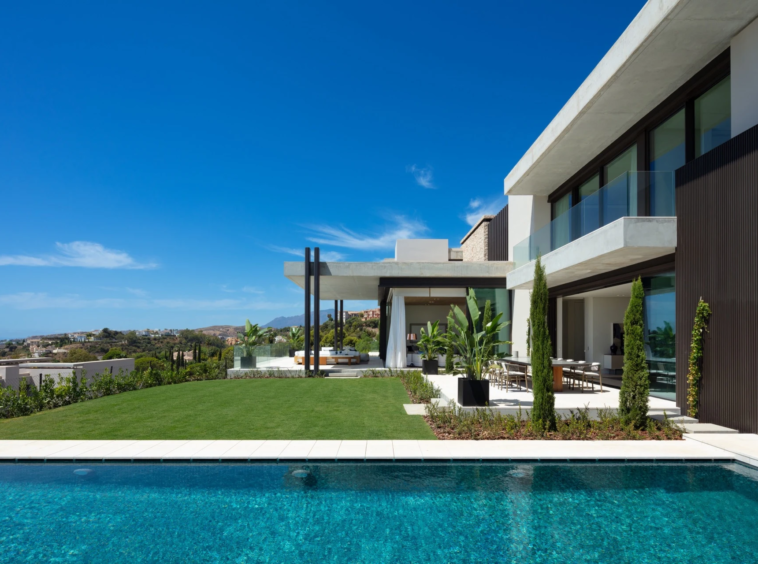 Private pool beside the villa facade and landscaped lawn