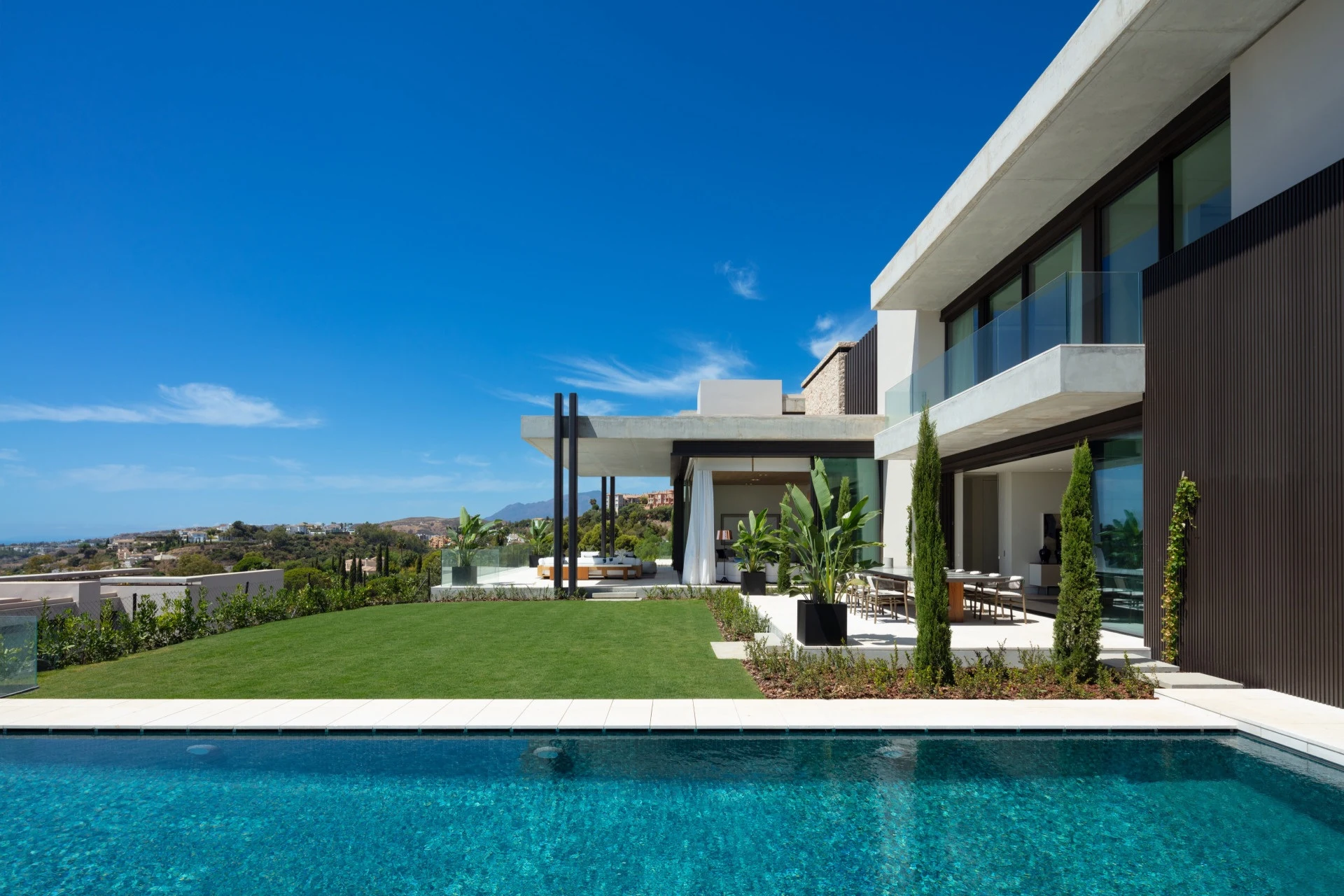 Private pool beside the villa facade and landscaped lawn