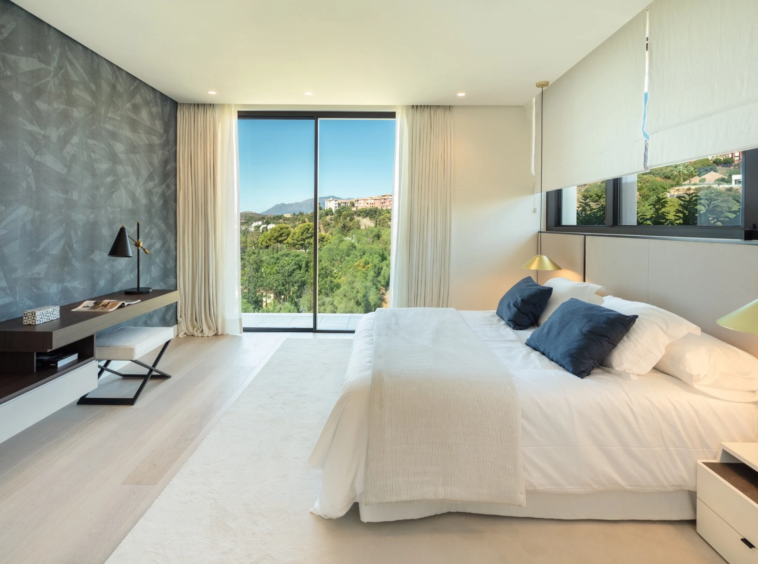 Bright bedroom with a stone accent wall and garden outlook