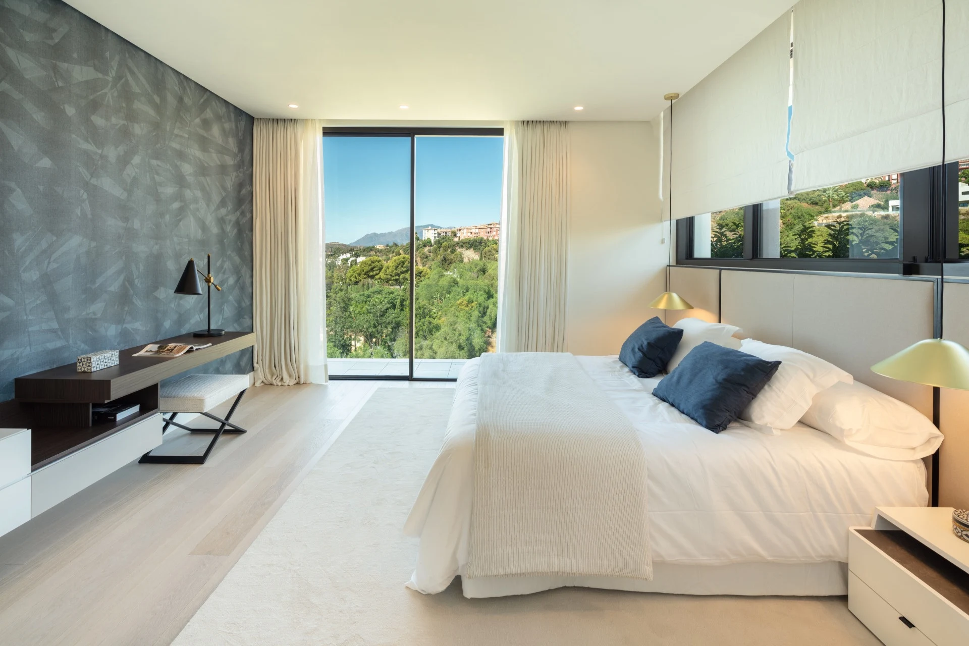 Bright bedroom with a stone accent wall and garden outlook