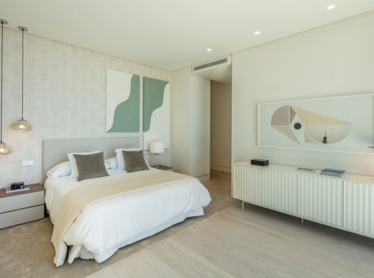 Guest bedroom with pale furnishings and decorative wall panels