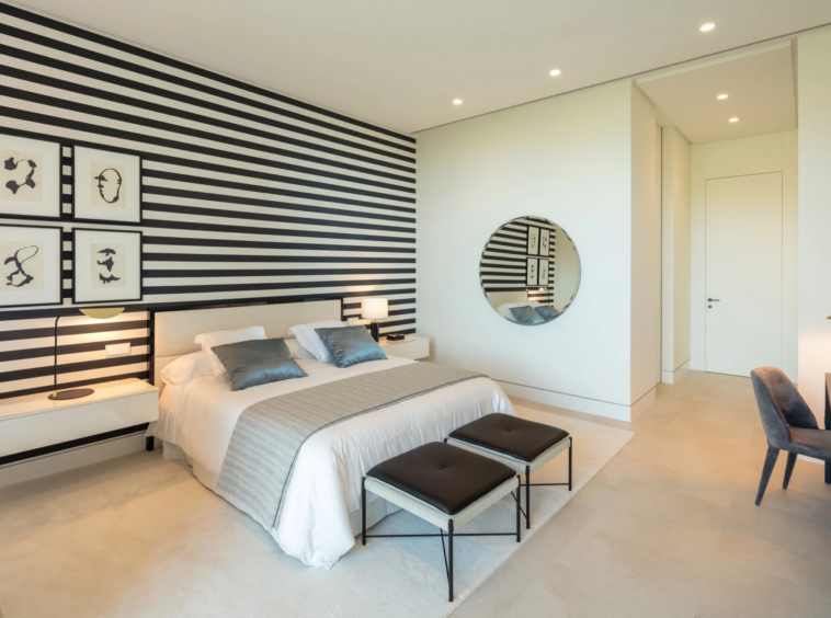 Bedroom with striped wall detailing and a writing desk