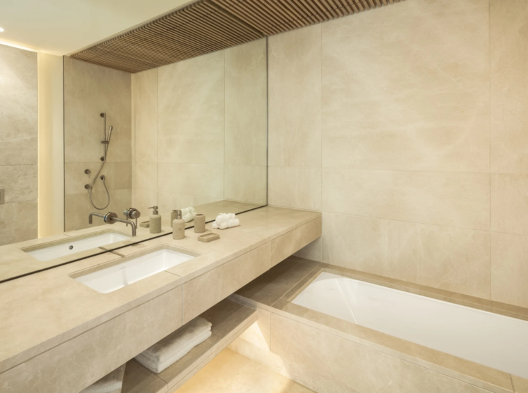 Bathroom with stone finishes, twin basins and a bathtub
