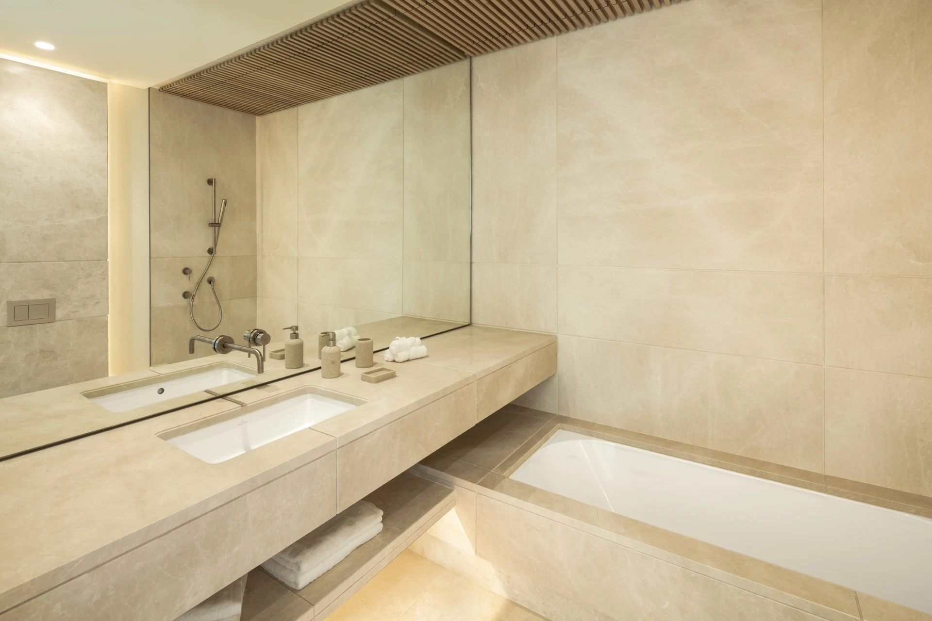 Bathroom with stone finishes, twin basins and a bathtub