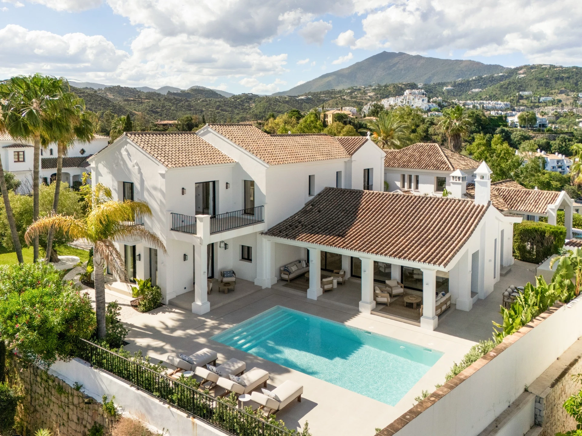 Elevated view of the villa and pool with mountains behind