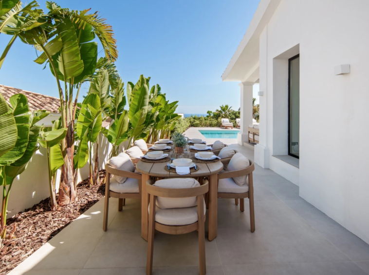 Outdoor dining area beside tropical planting