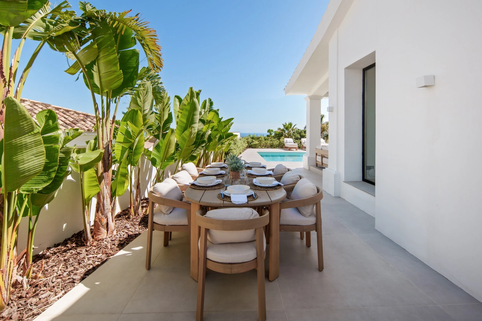 Outdoor dining area beside tropical planting