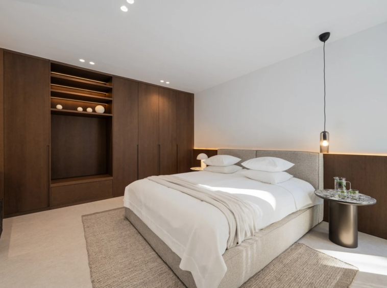 Bedroom with fitted headboard and warm lighting