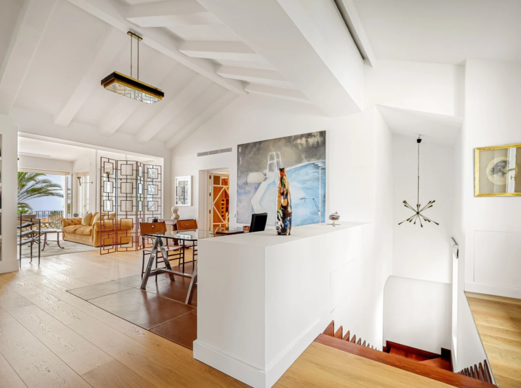 Home office with built-in shelves and high ceiling